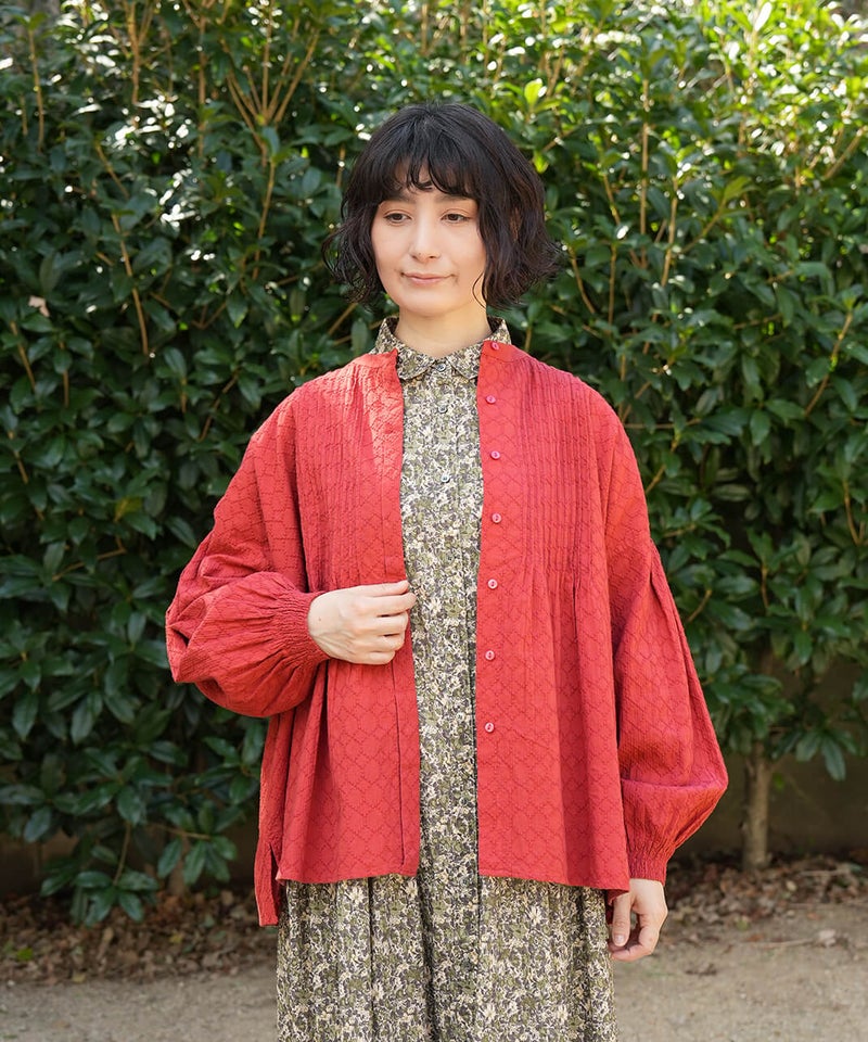 サークル刺繍のピンタックギャザーブラウス。レッドを羽織った着用イメージ